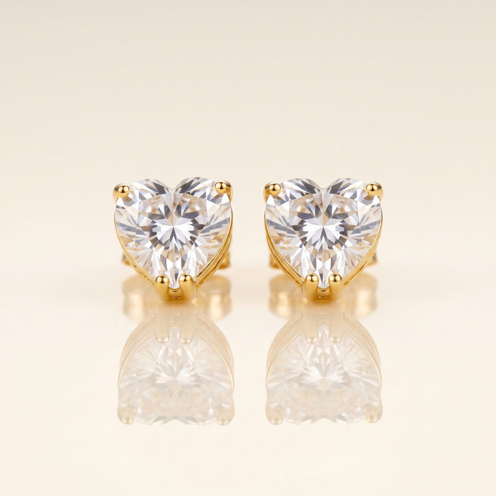 A pair of heart-shaped stud earrings with clear faceted gemstones in gold prong settings