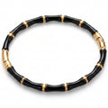 A black and gold beaded bracelet with a bamboo-inspired segmented design, displayed on a clean white background.