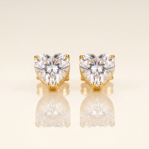 A pair of heart-shaped stud earrings with clear faceted gemstones in gold prong settings
