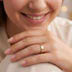 A gold band ring with a continuous scalloped or wavy textured edge, 
