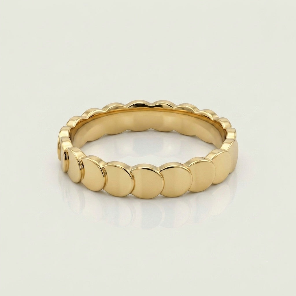 A gold band ring with a continuous scalloped or wavy textured edge, 