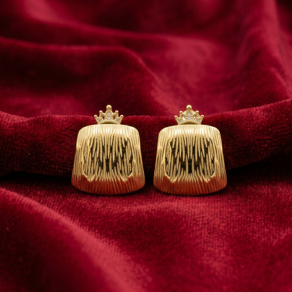 A pair of gold clutch-style earrings with a crown-shaped top and a vertically ribbed, textured body