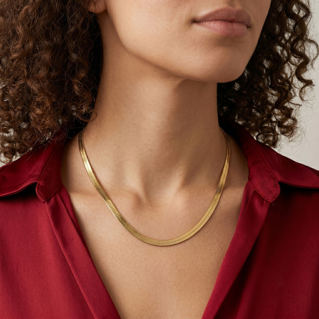Woman wearing a gold necklace with a red shirt