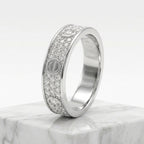 A silver-tone diamond band ring with screw-head details, displayed on a white marble block against a clean white background.