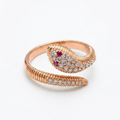 Rose gold snake-shaped ring with gemstones and red eyes