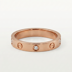 Rose gold ring with diamond accents and screw pattern