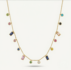 A gold chain necklace featuring multiple colorful gemstone charms in various shapes, including round, oval, and rectangular settings, displayed against a light off-white background.