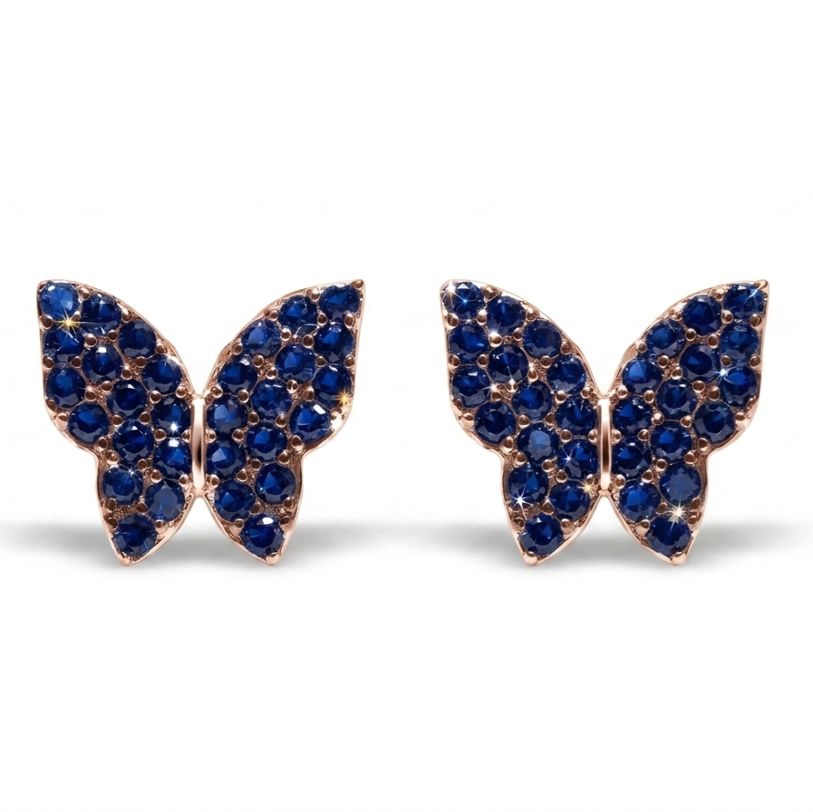 A pair of butterfly-shaped stud earrings set with deep blue gemstones in a rose gold-tone metal, displayed on a clean white background.