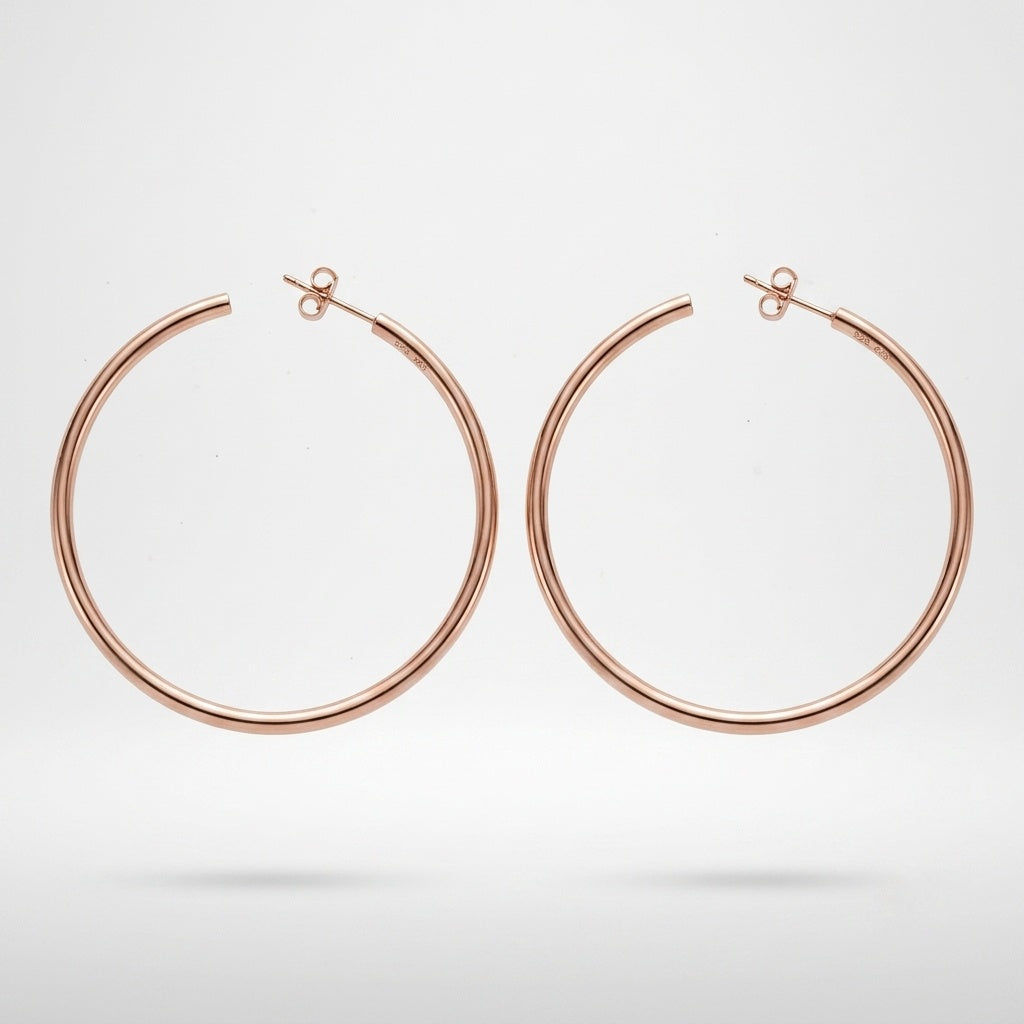A pair of minimalist, thin hoop earrings in a polished rose gold finish, displayed against a clean white background with a soft shadow underneath.