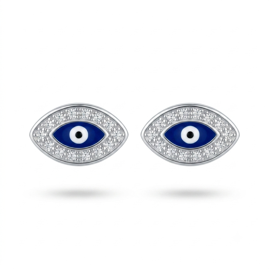 A pair of silver-toned evil eye stud earrings with blue enamel centers, white and black details, and clear pavé stones around the eyes, shown on a white background.