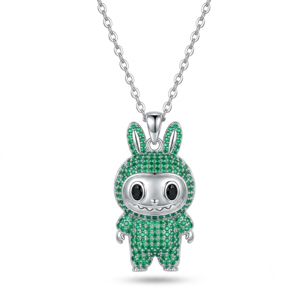 A silver pendant necklace featuring a cartoon bunny character encrusted with green stones, suspended from a silver chain against a white background.