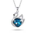 A silver-tone swan pendant necklace featuring a large faceted blue heart-shaped gemstone, surrounded by smaller clear crystals, on a white background.