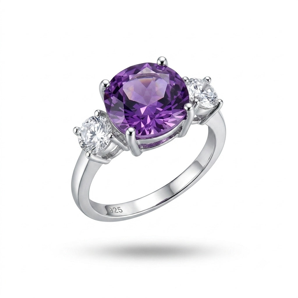 A silver three-stone ring featuring a large oval-cut purple amethyst center stone and two round clear accent stones on a white background.