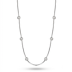 A silver-toned chain necklace featuring seven evenly spaced, round bezel-set clear stones, displayed against a clean white background.