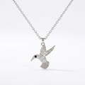 A silver-toned necklace featuring a detailed hummingbird pendant adorned with small clear stones, set against a clean white background.