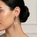 woman wearing a diamond earring with colored gemstones. triangular flower gold earrings with gemstones 