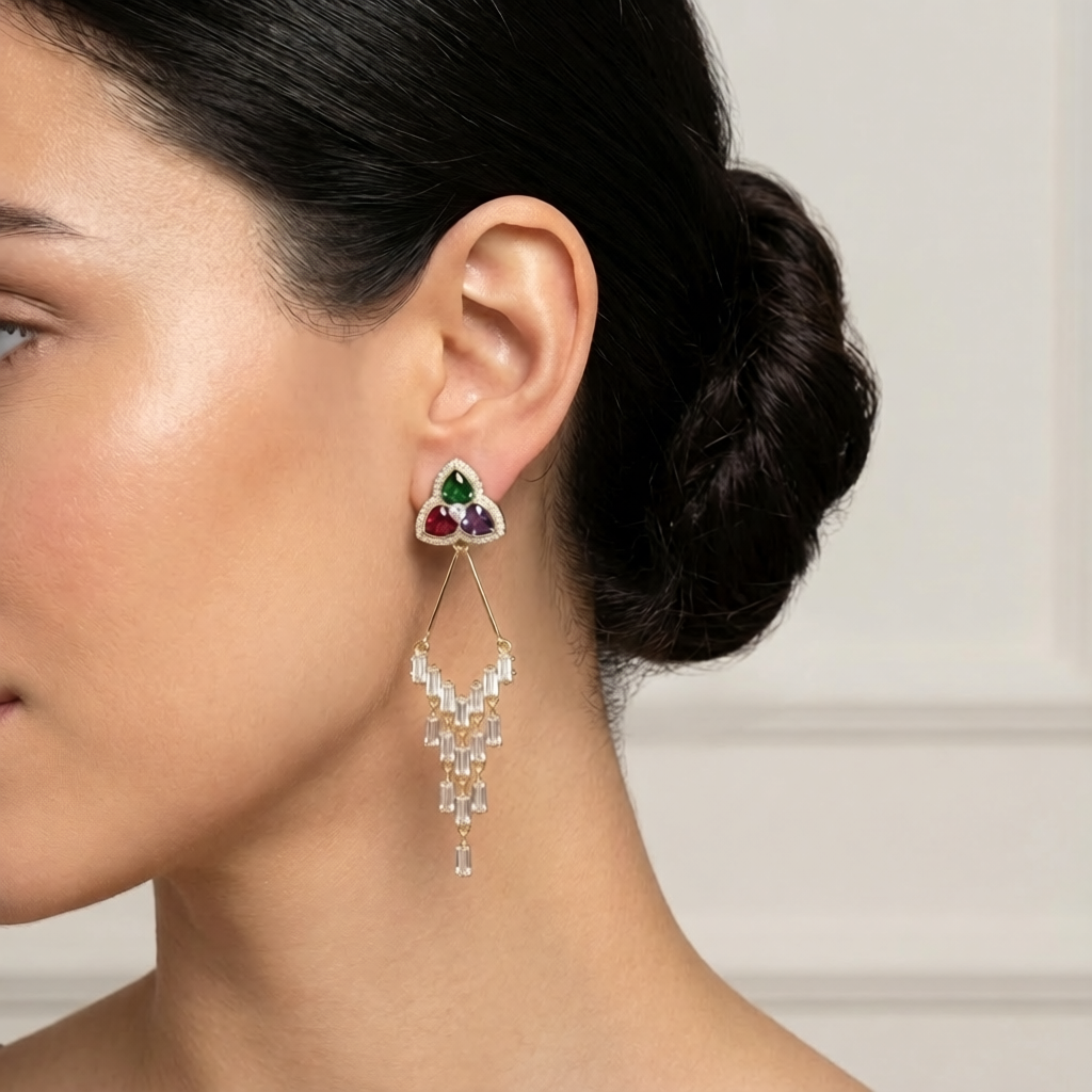 woman wearing a diamond earring with colored gemstones. triangular flower gold earrings with gemstones 