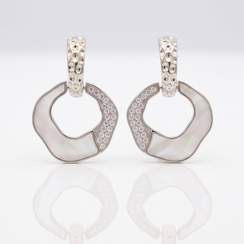 Pair of silver hoop earrings with gemstones on a light gray background