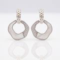 Pair of silver hoop earrings with gemstones on a light gray background