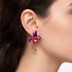 Close-up of a colorful floral earring on an ear with a blurred background