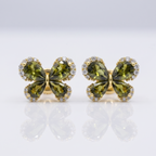 Pair of green butterfly-shaped earrings with gold accents on a white background