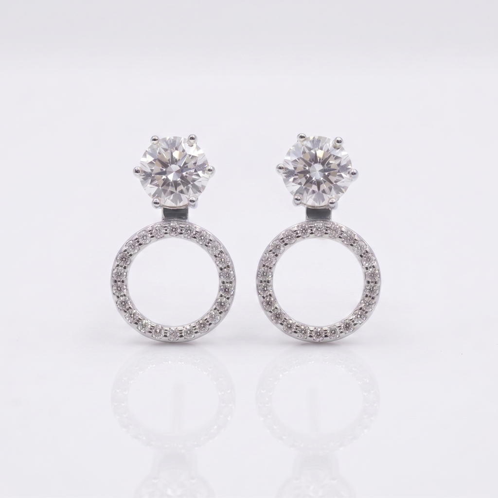 Pair of silver earrings with circular designs on a light gray background