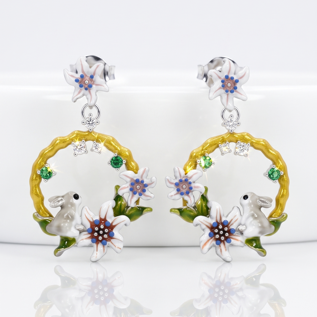 Pair of earrings with floral and animal designs on a white background