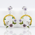 Pair of earrings with floral and animal designs on a white background