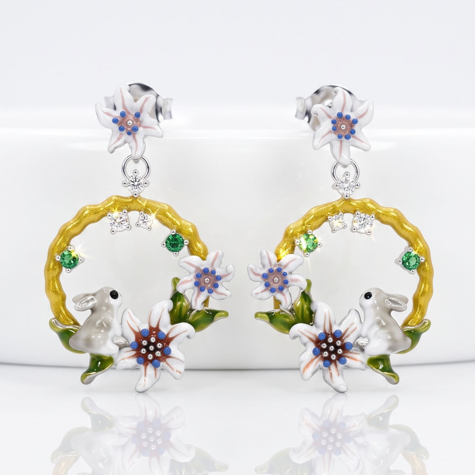 Pair of earrings with floral and animal designs on a white background