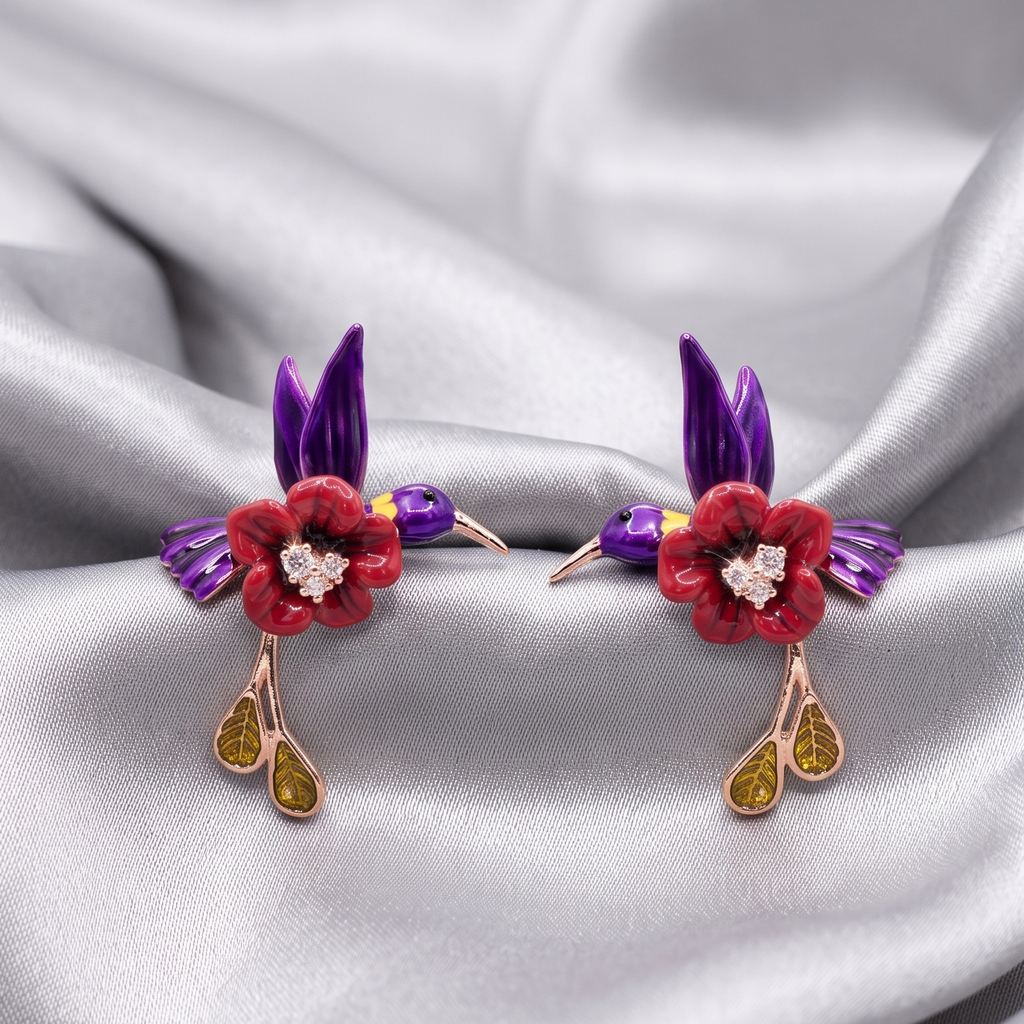 Pair of earrings with floral and bird design on a satin background