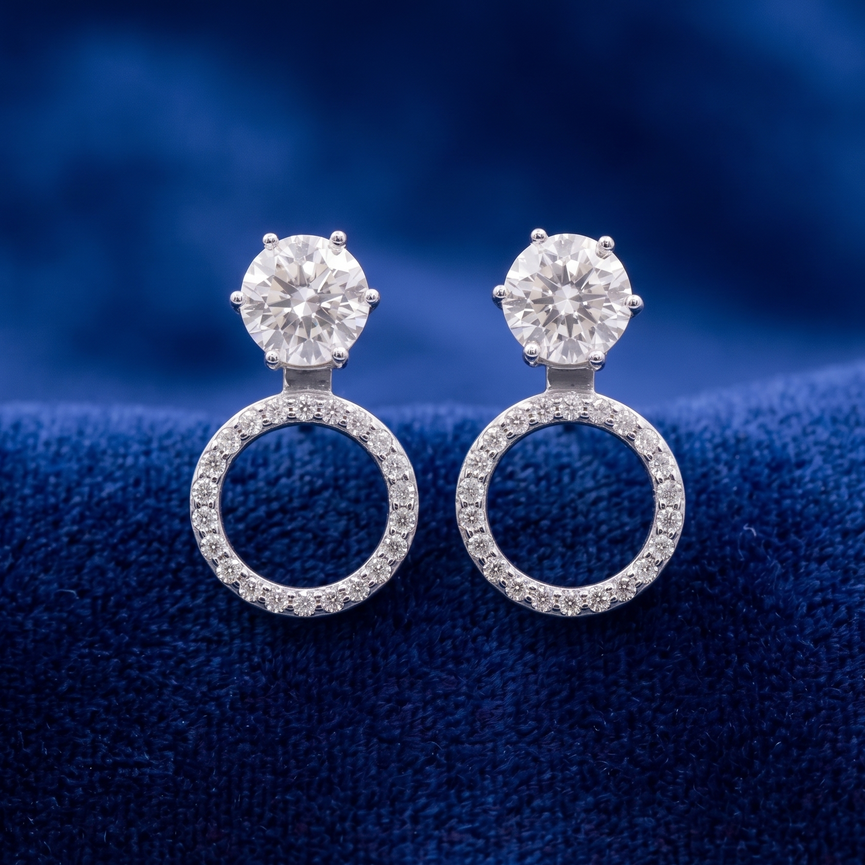 Pair of diamond earrings on a blue textured background