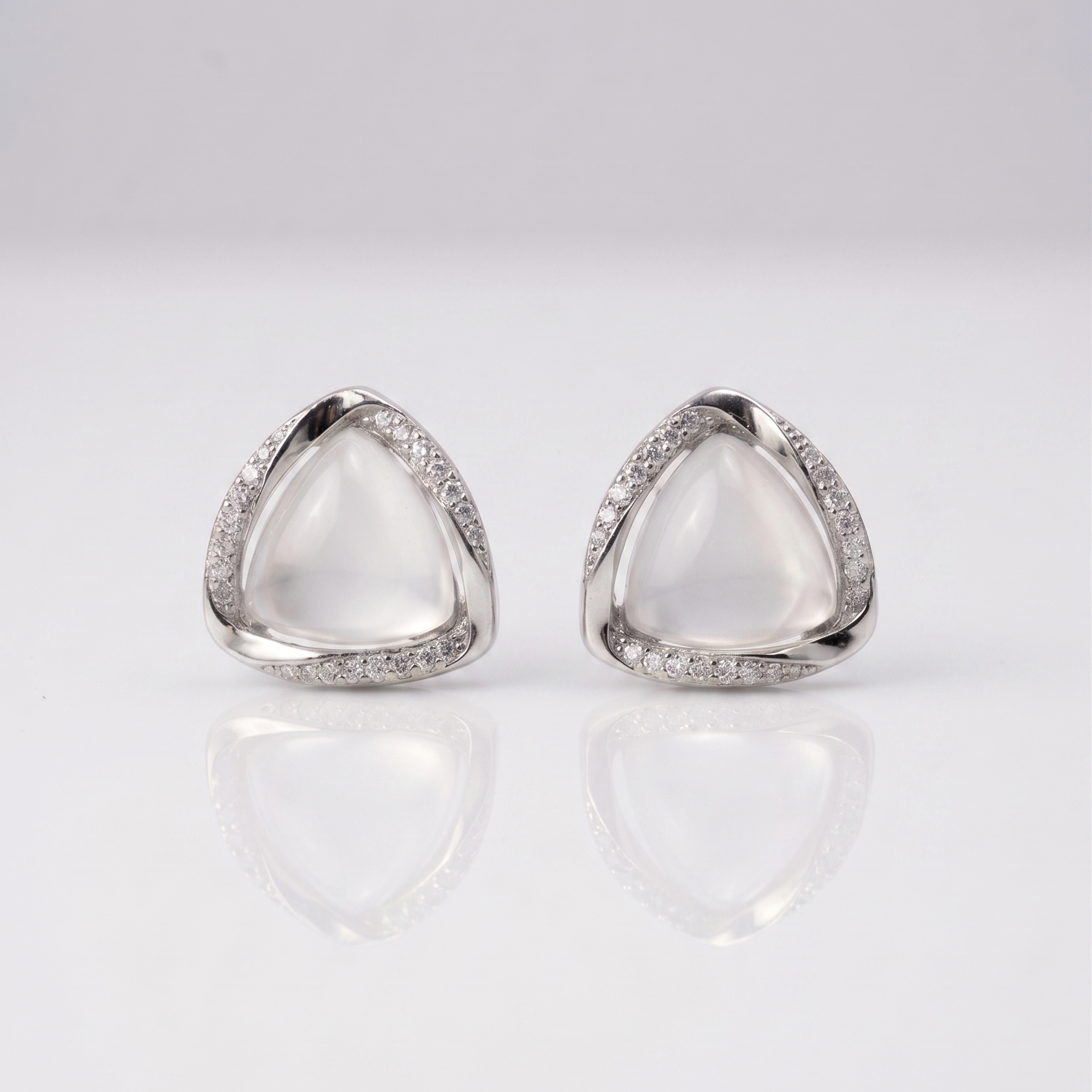 Pair of silver triangle earrings on a light gray background