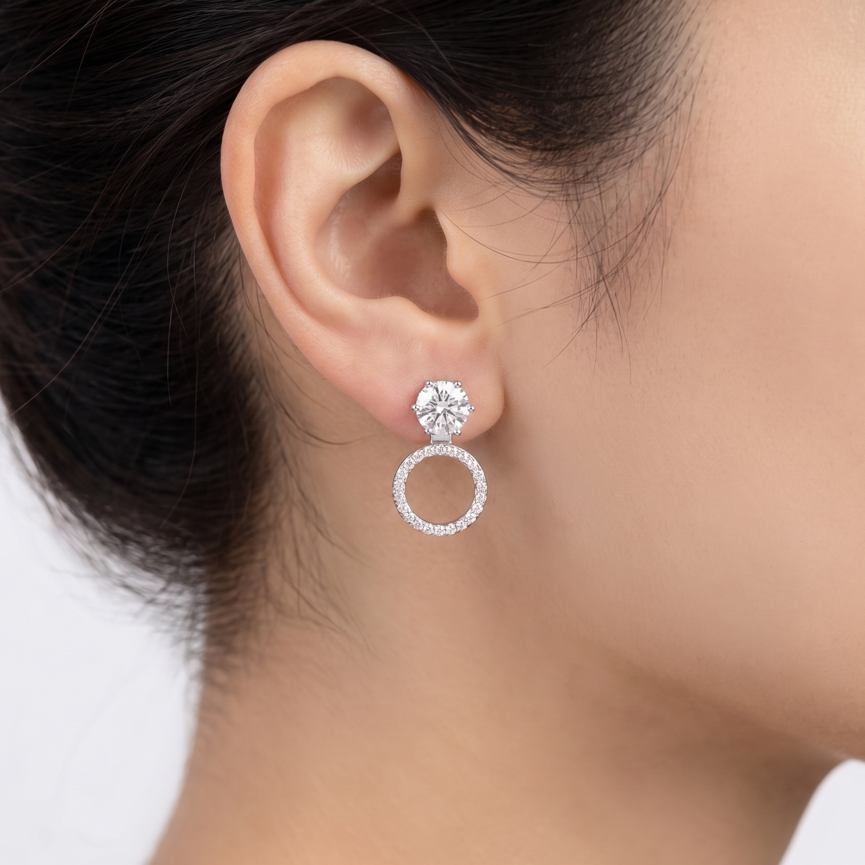 Close-up of an ear wearing a diamond earring with a blurred background