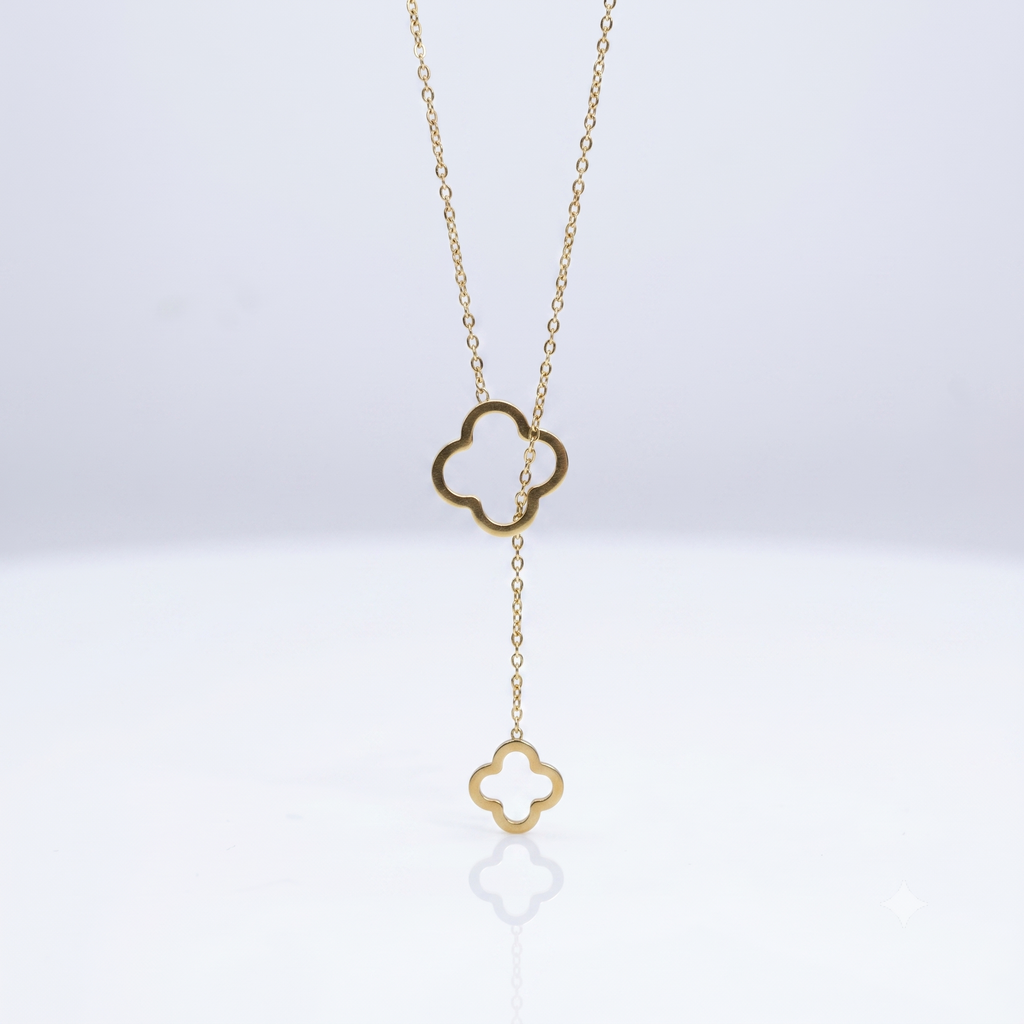 Gold necklace with clover-shaped pendant on a white background