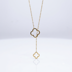 Gold necklace with clover-shaped pendant on a white background