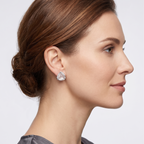 Woman wearing a clear teardrop earring on a plain background