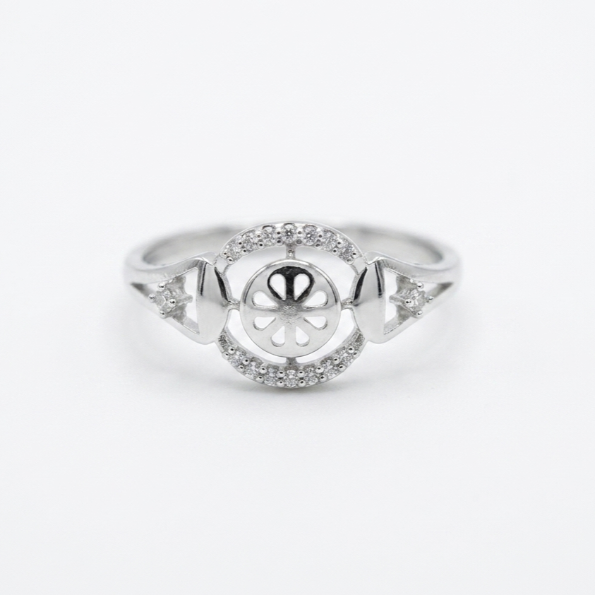 Silver ring with intricate design on a white background