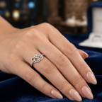 Hand wearing a silver ring with a blue fabric background