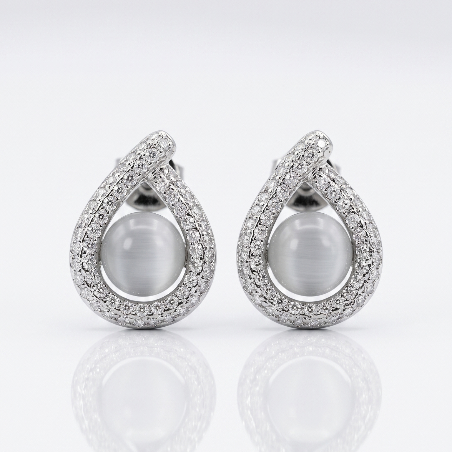 Pair of silver earrings with large gemstones on a white background