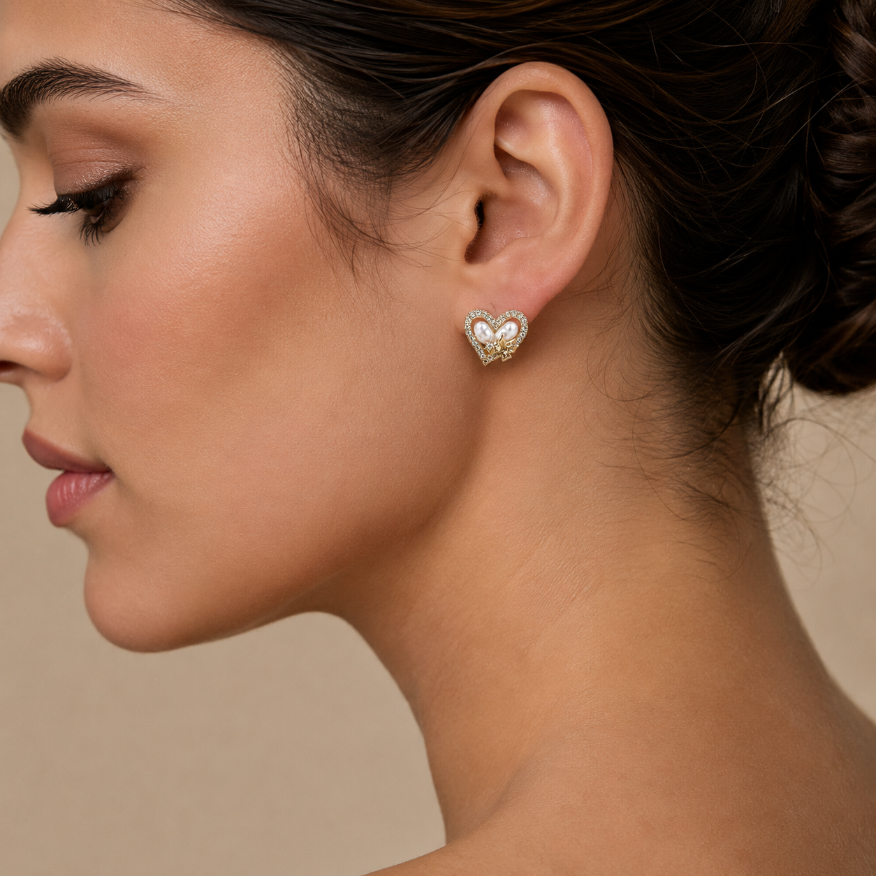 woman wearing a Heart-shaped earrings with pearls and gold accents and diamonds
