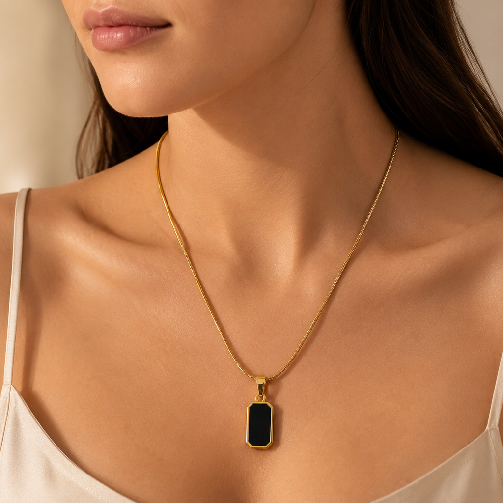 Gold necklace with a black pendant on a girl