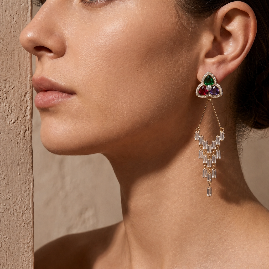 Close-up of a woman wearing a diamond earring with gemstones. Pair of triangular flower gold earrings with gemstones 