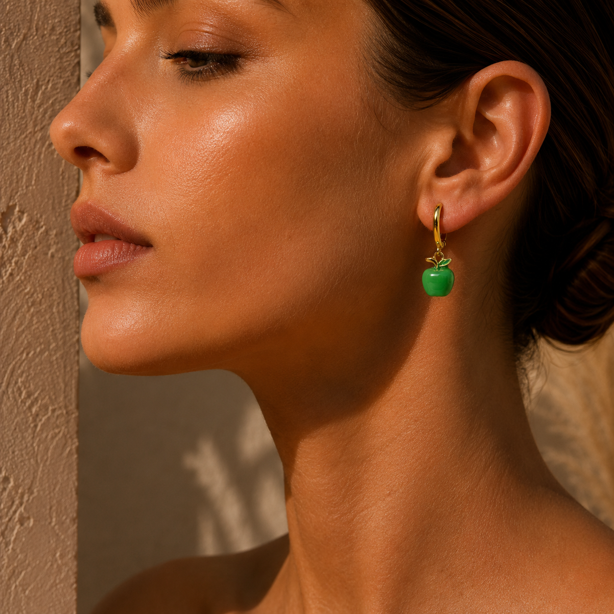 woman wearing a Gold hoop earrings with green apple charms